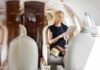 A woman in a private jet using a tablet while seated elegantly