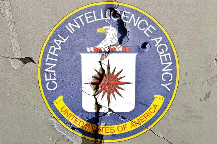 Cracked CIA logo on weathered wall.