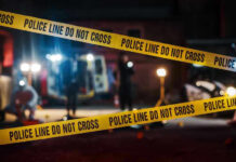 Yellow police tape in front of crime scene.