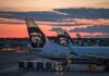Aircraft tails with a sunset backdrop at an airport