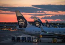 Aircraft tails with a sunset backdrop at an airport