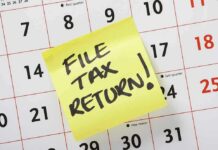 A sticky note on a calendar reminding to file tax return