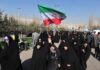 Iran’s Top Diplomat Challenges Hardliners—Peace Now! Group of women in black attire marching with an Iranian flag
