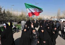 Iran’s Top Diplomat Challenges Hardliners—Peace Now! Group of women in black attire marching with an Iranian flag