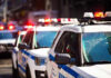 Police cars with flashing lights in line formation.