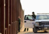 Abolish ICE? Candidate’s Bold Arrest Pledge Border patrol agents near a tall metal fence.