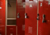Feds Clash With School Over Trans Locker Room Drama Red lockers with padlocks, one open with hanger.