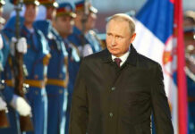 Putin Shocks With War’s End Prediction A man in dark coat at a military event.