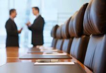 Two business professionals engaged in conversation in a conference room