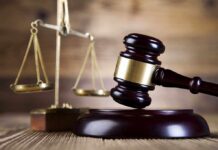 Surprise Twist in Elite Murder Trial A wooden gavel and scales of justice on a wooden surface