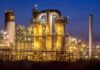 Emergency: Explosive Chemical Evacuation An industrial facility with illuminated structures at night