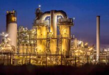 Emergency: Explosive Chemical Evacuation An industrial facility with illuminated structures at night