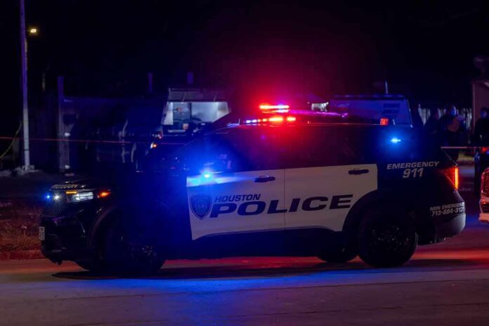 shutterstock_2414107305-2 Houston police vehicle with emergency lights activated at night
