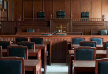 Tax-Funded Threats Target Congresswoman Empty courtroom with wooden furnishings and judges bench.