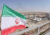 Iran ‘Dismantles’ Nukes? Watch The Fine Print Iranian flag near an industrial gas refinery.