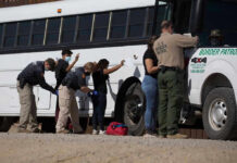 Trump’s Border Flip Shocks Cartels Border patrol officers investigating people near a bus.