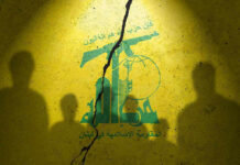 Ceasefire Without Hezbollah? What Could Go Wrong Yellow wall with cracked logo and shadowy figures.