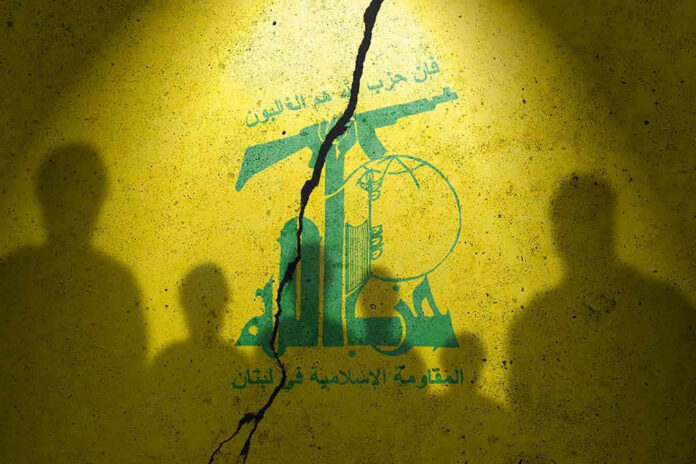 2373422413 Yellow wall with cracked logo and shadowy figures.
