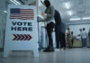 Sign reading Vote Here in a polling station.