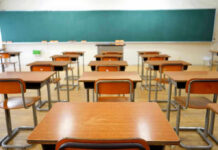 Predatory Teacher Exposed—New Rink Claims Erupt Empty classroom with desks and a chalkboard.
