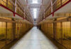 Early Release Bombshell Rocks North Carolina Long hallway with prison cells on both sides.