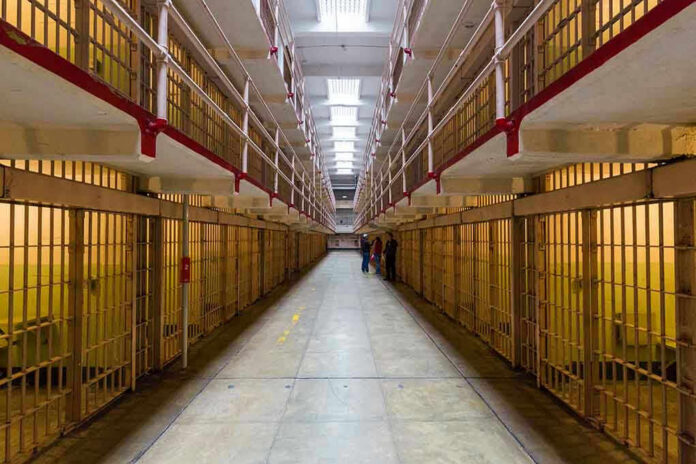 372127549 Long hallway with prison cells on both sides.