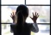 Watchdog Bombshell: 291,000 Kids Vanish A child with long hair presses their hands against a window, looking outside
