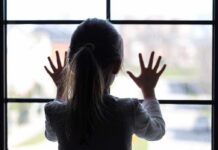 Watchdog Bombshell: 291,000 Kids Vanish A child with long hair presses their hands against a window, looking outside