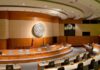 Pentagon Shock: Israel Labeled ‘Critical’ Threat? Interior view of a government chamber with wooden paneling and seating