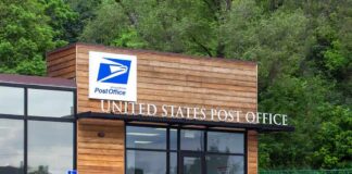 Exterior view of a modern United States Post Office building surrounded by greenery