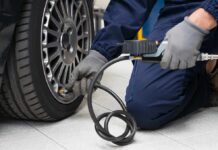 Mechanic inflating a car tire in a workshop