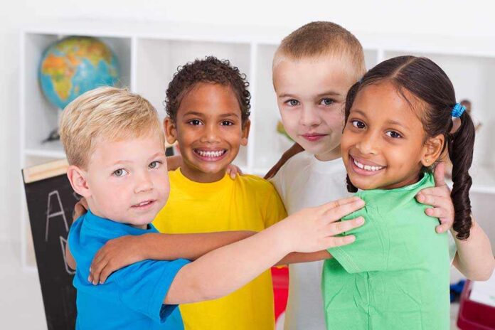 Group,Of,Happy,Preschool,Kids,Hugging Four children of diverse backgrounds smiling and hugging each other in a classroom
