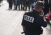 Attempted Beheading Shocks Belfast Street Police officer in uniform communicating with a crowd in an urban setting