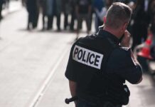 Attempted Beheading Shocks Belfast Street Police officer in uniform communicating with a crowd in an urban setting