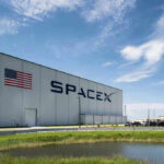 Last-Second Abort Stuns SpaceX SpaceX building with American flag and launch pad.