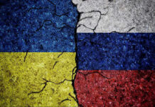 Power Brokers Carve Ukraine’s Future Cracked Ukrainian and Russian flags painted on concrete.