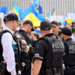 Stunning Lapses Put Trump In The Crosshairs Police officers gathered near a crowd with flags.