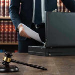 Backroom Brawl Over Who Picks Graham’s Seat Gavel, lawyer, briefcase, and legal books on the table.