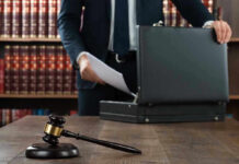 Gavel, lawyer, briefcase, and legal books on the table.