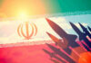 IRAN Hits Tankers — Trump Hammers Back Silhouettes of missiles over Irans flag graphic.