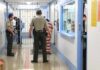 Corrections officers escort an inmate in a jail hallway