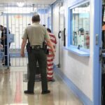 Paroled Baby Killer Back Behind Bars Corrections officers escort an inmate in a jail hallway
