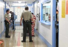 Paroled Baby Killer Back Behind Bars Corrections officers escort an inmate in a jail hallway