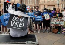 Communists vs. Common Sense? Johnson Drops Bomb Protesters holding signs at a voting rights rally
