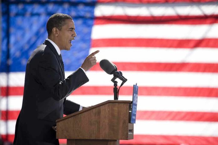 Speaker at podium with microphones in front of US flag