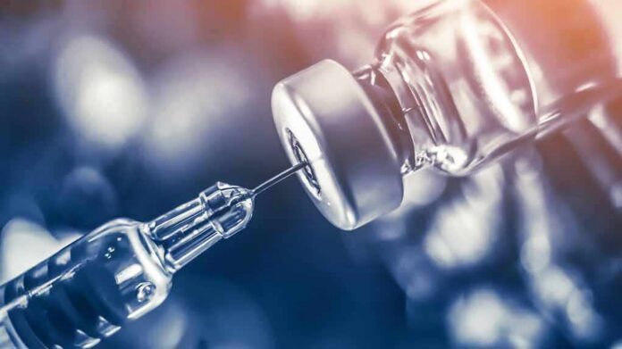 shutterstock_1046242816 syringe needle drawing liquid from a vaccine vial