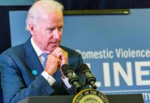 Painful Turn: Biden’s Cancer Spreads man at podium speaking with hands clasped near chin