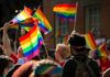 Republican Gay Icon Ditches Trans Fight Crowd waving rainbow flags at an outdoor event