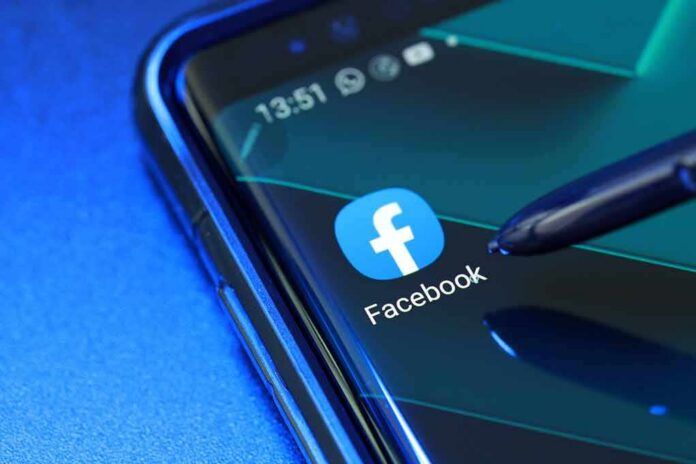 shutterstock_1683486193 Facebook app icon on smartphone screen with stylus