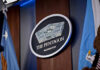 Hegseth Slashes Generals – 20% Gone The Pentagon emblem between two flags.